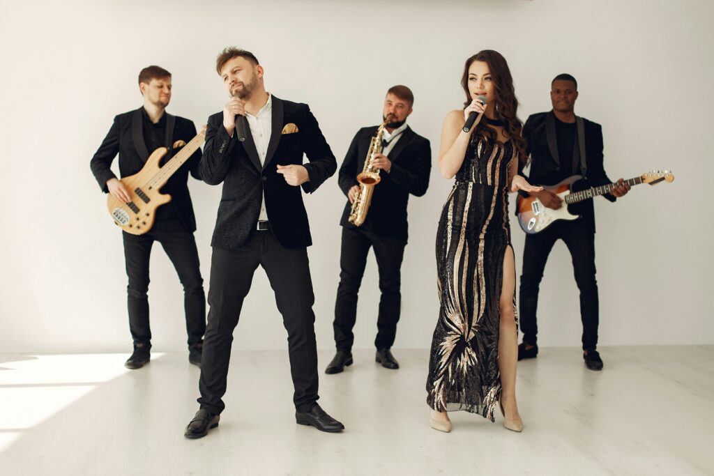 A stylish jazz band performing indoors with two vocalists and musicians in black attire.